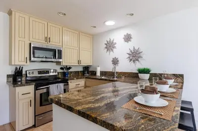 a kitchen with white cabinets and a marble counter top at SB-6758 - Italian Coastal Getaway in Solana Beach