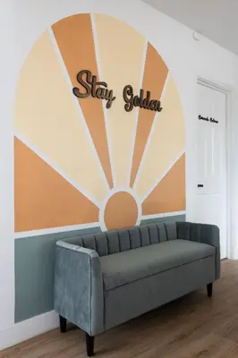 a couch in a room with a sign that reads stay golden at *Golden Getaway* 5 Beds / 8 Minutes to Downtown in San Diego