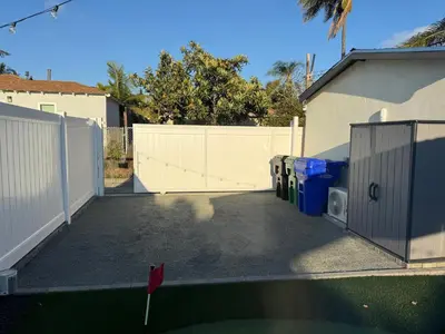 a parking lot with a fence and trash cans at *Golden Getaway* 5 Beds / 8 Minutes to Downtown in San Diego