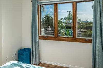 a bedroom with a window with a view of palm trees at Cozy Family Getaway home in Carlsbad