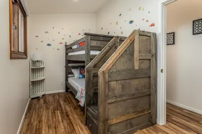 a bunk bed in a childs room with wooden floors at Cozy Family Getaway home in Carlsbad