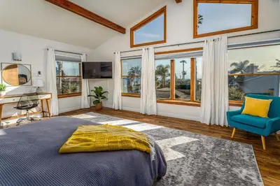 a bedroom with a bed and a desk and windows at Cozy Family Getaway home in Carlsbad