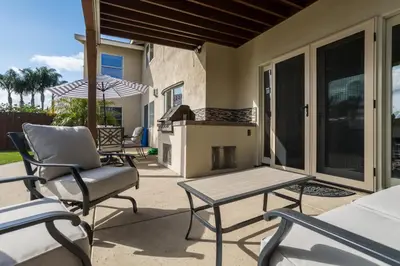 a patio with chairs and a table and a grill at Cozy Family Getaway home in Carlsbad