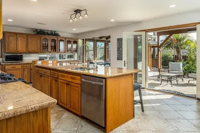 a kitchen with wooden cabinets and stainless steel appliances at Cozy Family Getaway home in Carlsbad
