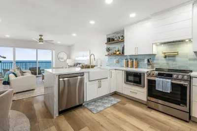 a kitchen with white cabinets and a view of the ocean at Del Mar Gem condo in Solana Beach