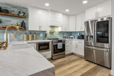 a kitchen with white cabinets and stainless steel appliances at Del Mar Gem condo in Solana Beach