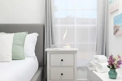 a bed with a night stand next to a window at 3 Bedroom 2 Bath House with Parking - 10 Guests in San Diego