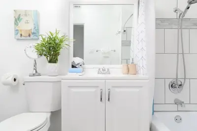 a white bathroom with a toilet and a sink at 3 Bedroom 2 Bath House with Parking - 10 Guests in San Diego