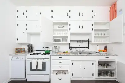 a white kitchen with white cabinets and appliances at 3 Bedroom 2 Bath House with Parking - 10 Guests in San Diego