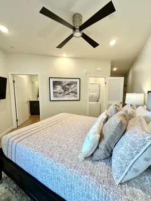 a bedroom with a bed with a ceiling fan at Nimitz Crossing Luxury Residences in San Diego