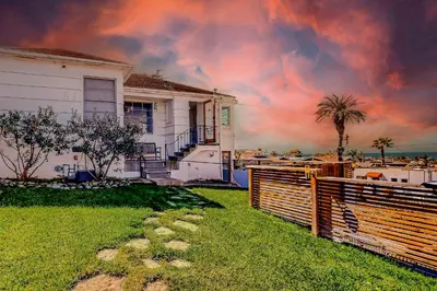a house with a fence and a palm tree at Sea Side Beauty in San Diego