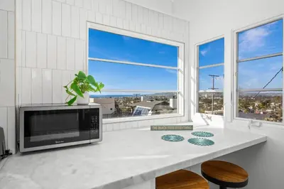 a kitchen with a counter with a microwave and windows at Sea Side Beauty in San Diego