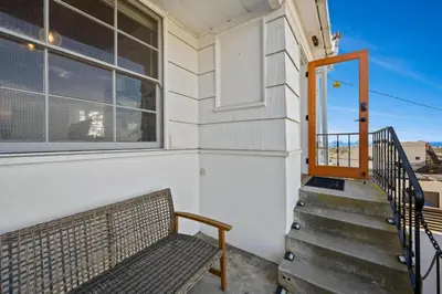 a bench sitting on the porch of a house at Sea Side Beauty in San Diego