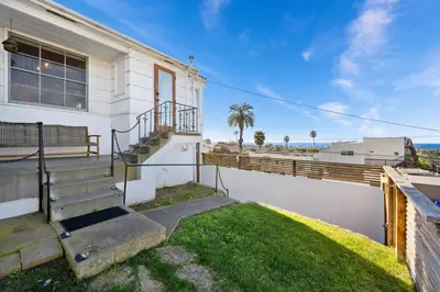 a white house with stairs and a balcony at Sea Side Beauty in San Diego
