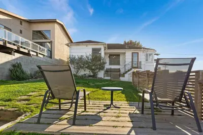 two chairs and a table in front of a house at Sea Side Beauty in San Diego
