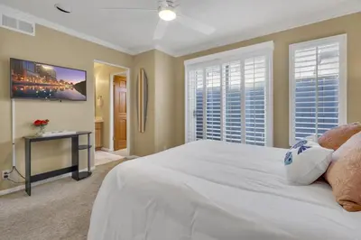 a bedroom with a large white bed and windows at Pine Street #2 in Oceanside