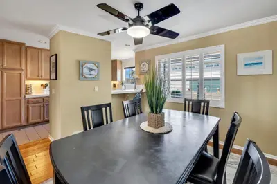 a dining room with a table and chairs and a ceiling fan at Pine Street #2 in Oceanside