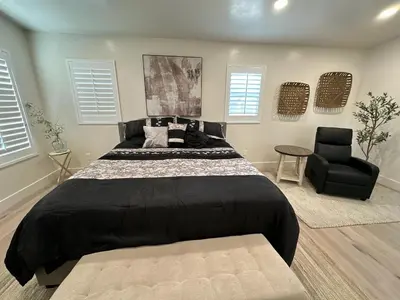 a bedroom with a large bed and a chair at Luxury Resort•POOL/SPA/Golf/Grill/Games/Sleep 40+ in Lakeside
