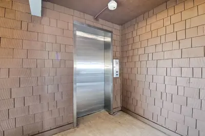 a metal elevator in a brick wall at Oceanfront 1BR, Fully Furnished, Gated Parking in Oceanside