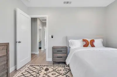 a white bedroom with a large bed and a wooden floor at San Diego Heights - Urban Legend in San Diego