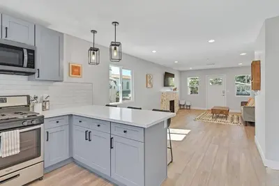 a kitchen with white cabinets and a living room at San Diego Heights - Urban Legend in San Diego