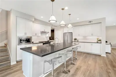 a kitchen with white cabinets and a large island with bar stools at King Size, Patio, Xbox, Great Park in Irvine