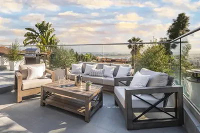 a patio with couches and a table on a balcony at 4 Bedroom 2 Bath with Ocean View Hot Tub Parking in San Diego