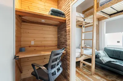 a tiny house with a loft bed and a desk at Good Life Resorts in San Diego