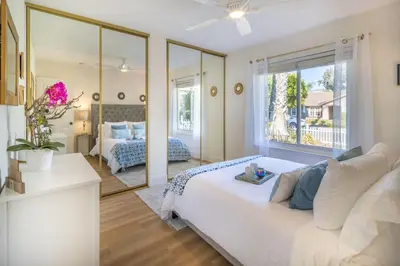 a bedroom with a white bed and a large window at Stunning 4 Bedroom 1 Level- Pool, Spa, Grass Yard, Fire Pit, Garage, BBQ in Mission Viejo