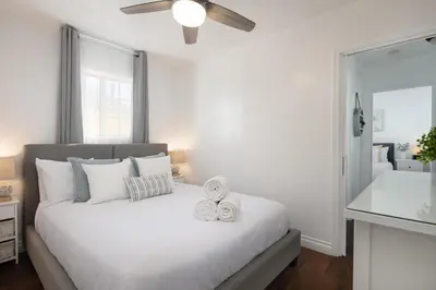 a bedroom with a white bed with two towels on it at 3 Bedroom House - Fire Pit Table BBQ - 10 Guests in La Mesa