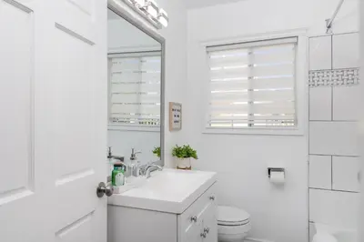 a white bathroom with a sink and a toilet at 3 Bedroom House - Fire Pit Table BBQ - 10 Guests in La Mesa