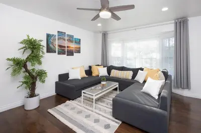 a living room with a couch and a ceiling fan at 3 Bedroom House - Fire Pit Table BBQ - 10 Guests in La Mesa