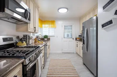 a kitchen with a refrigerator and a stove top oven at 3 Bedroom House - Fire Pit Table BBQ - 10 Guests in La Mesa