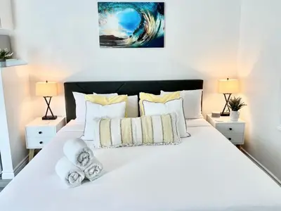 a bedroom with a large white bed with two lamps at Hidden King Suite with Garden Parking - 4 Guest in La Mesa