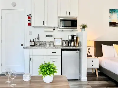 a kitchen with white cabinets and a sink and a bed at Hidden King Suite with Garden Parking - 4 Guest in La Mesa