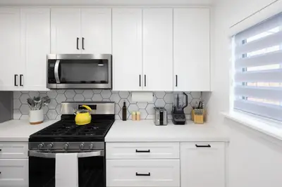 a white kitchen with a stove and a microwave at 2 Bedroom House - Fire Pit Table BBQ - Downtown in San Diego