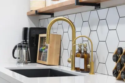 a kitchen counter with two gold faucets and a sink at 2 Bedroom House - Fire Pit Table BBQ - Downtown in San Diego
