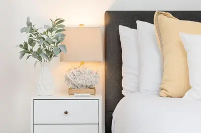 a vase of flowers on a night stand next to a bed at 2 Bedroom - Ocean View Hot Tub Parking - 8 Guest in San Diego