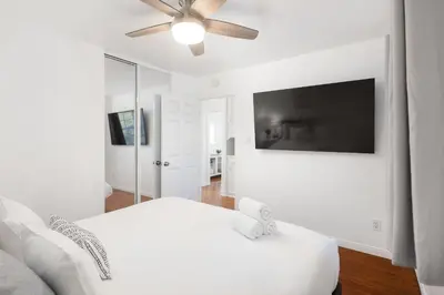 a white bedroom with a bed and a ceiling fan at 2 Bedroom - Ocean View Hot Tub Parking - 8 Guest in San Diego