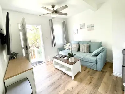 a living room with a blue couch and a table at Hidden Gem with Hot Tub and Parking - 4 Guests in San Diego