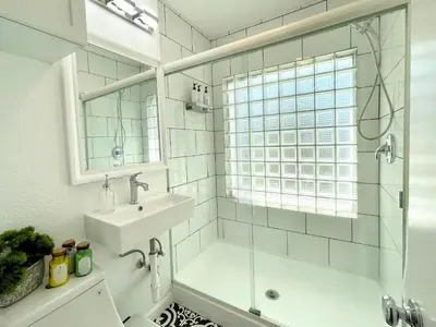a white bathroom with a sink and a shower at Hidden Gem with Hot Tub and Parking - 4 Guests in San Diego