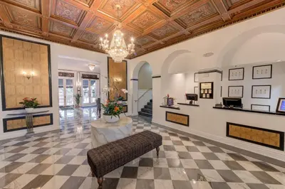 a lobby with a couch and a chandelier at Inn at the Park: San Diego Suites in San Diego