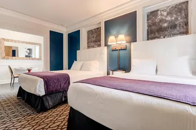 a hotel room with two beds and a table at Inn at the Park: San Diego Suites in San Diego