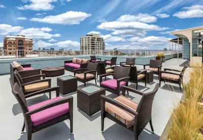 a patio with chairs and tables and a pool at Inn at the Park: San Diego Suites in San Diego