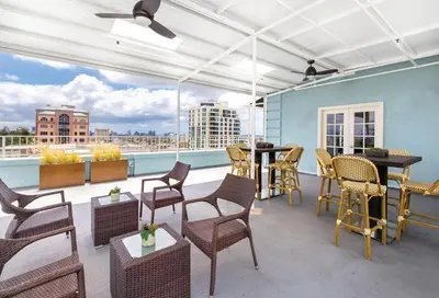 a patio with tables and chairs on a balcony at Inn at the Park: San Diego Suites in San Diego