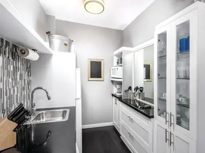 a kitchen with white cabinets and a sink at Inn at the Park: San Diego Suites in San Diego