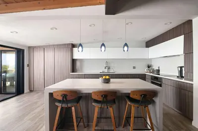 a kitchen with a large island with two bar stools at Panoramic Ocean sunset Views with Heated Pool & Spa best location in San Diego