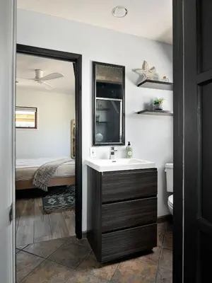 a bathroom with a sink and a mirror and a bed at Panoramic Ocean sunset Views with Heated Pool & Spa best location in San Diego