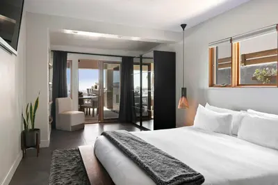 a bedroom with a large white bed and a balcony at Panoramic Ocean sunset Views with Heated Pool & Spa best location in San Diego