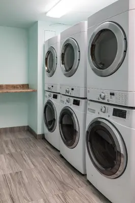 three washers and dryers in a laundry room at San Diego - Mission Valley Condos in San Diego